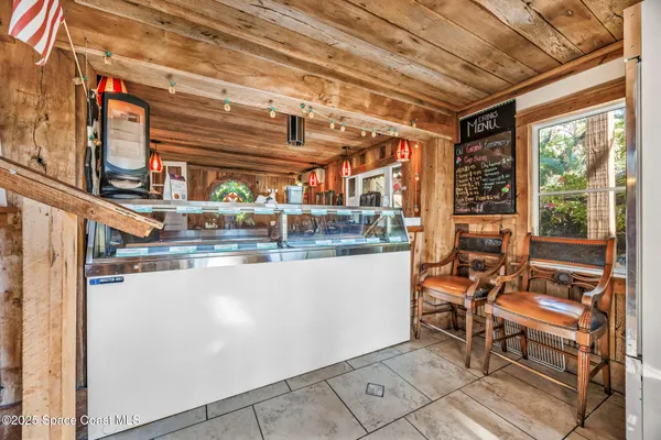 a dining room with furniture floor to ceiling windows and wooden floor