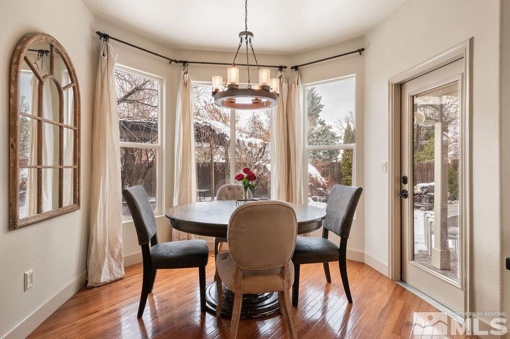 9985 Moccasin Court Reno, NV 89521 - Photo 12 of 40 a dining room with furniture a chandelier and wooden floor