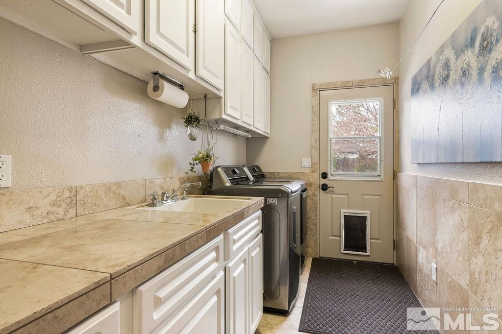 9985 Moccasin Court Reno, NV 89521 - Photo 19 of 40 a utility room with cabinets washer and dryer