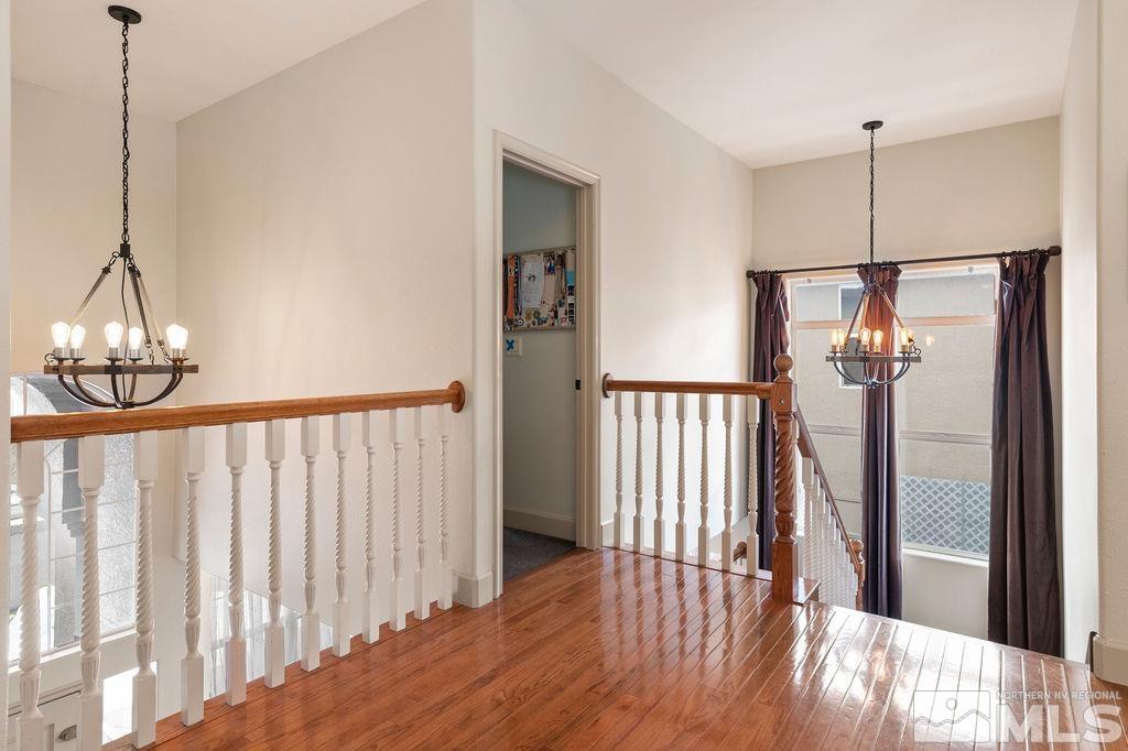 9985 Moccasin Court Reno, NV 89521 - Photo 22 of 40 a view of a hallway with wooden floor and stairs