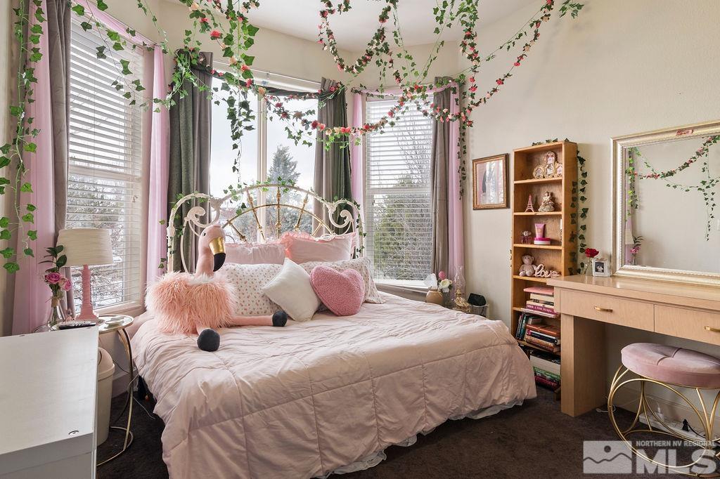 9985 Moccasin Court Reno, NV 89521 - Photo 27 of 40 a bedroom with a large bed and a chandelier