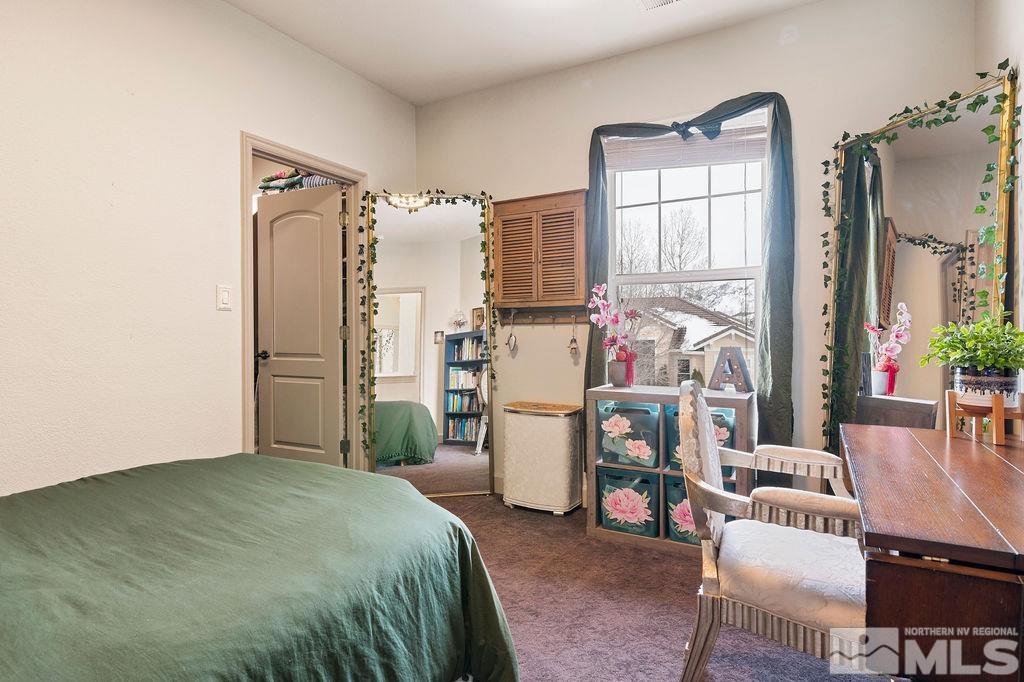 9985 Moccasin Court Reno, NV 89521 - Photo 29 of 40 a bedroom with a bed a flat screen tv and a large window