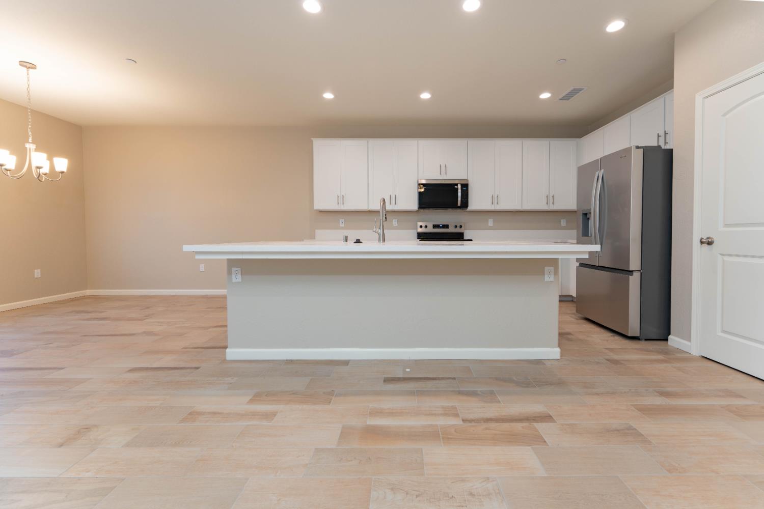30480 Bellwood Road Visalia, CA 93291 - Photo 6 of 37 a kitchen with kitchen island a sink a stove a refrigerator and cabinets