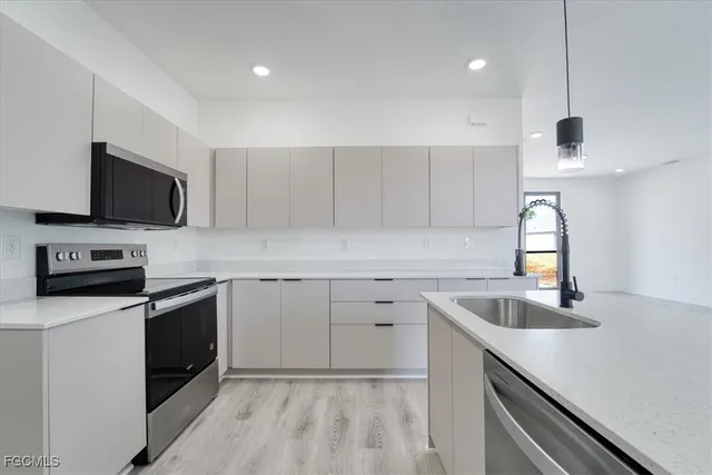 a kitchen with a sink stainless steel appliances and cabinets