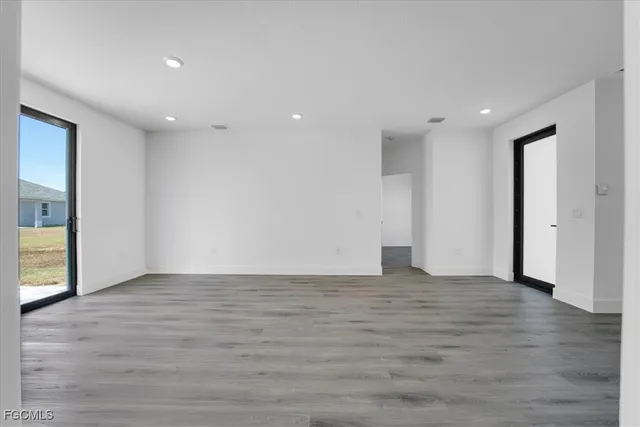 a view of an empty room with wooden floor