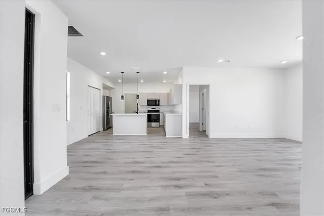 a view of a kitchen with a refrigerator and a stove top oven