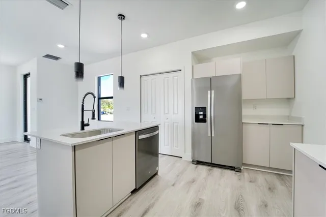 a kitchen with kitchen island a sink stainless steel appliances and cabinets