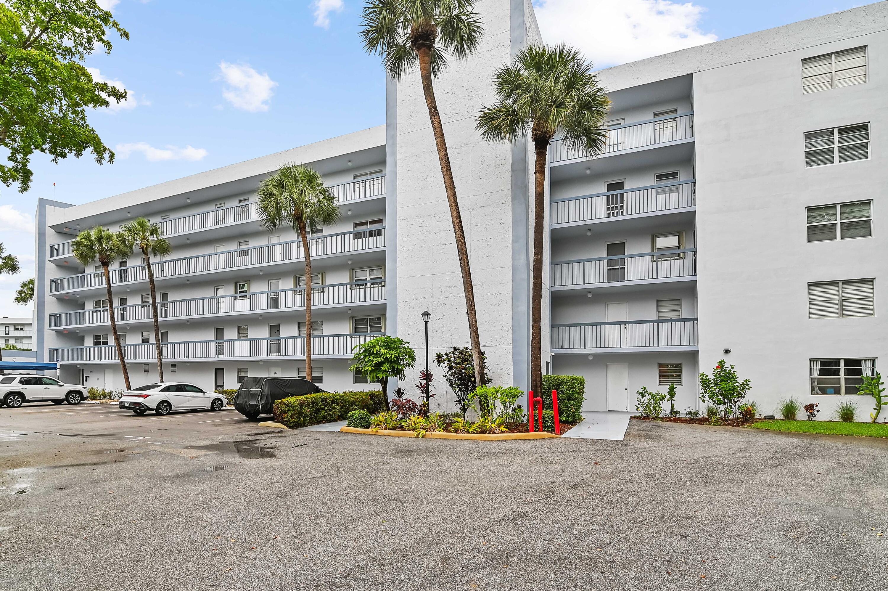 6400 Northwest 2nd Avenue, Unit 124 Boca Raton, FL 33487 - Photo 4 of 33 a row of palm trees sitting in front of a building