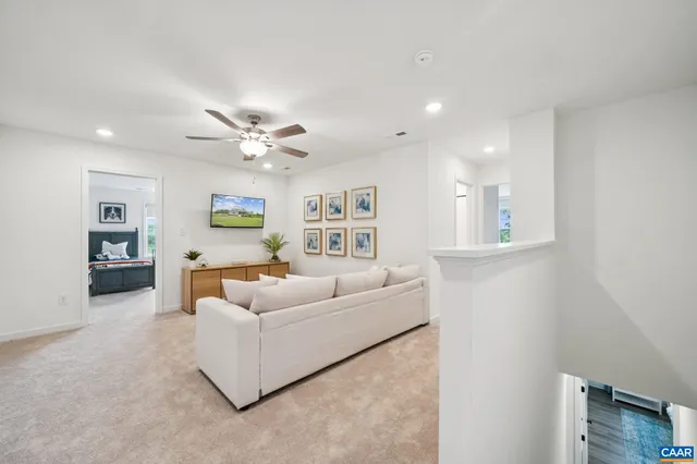 a living room with furniture and a ceiling fan