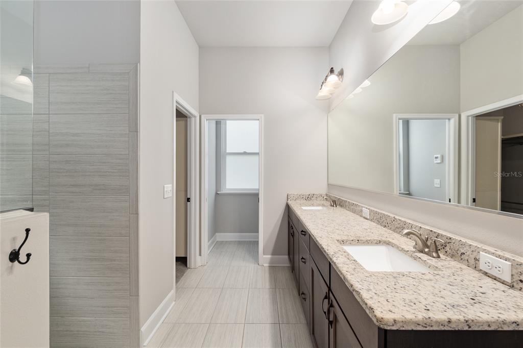2556 Southwest 118th Terrace Gainesville, FL 32608 - Photo 33 of 72 a bathroom with a granite countertop sink and a mirror