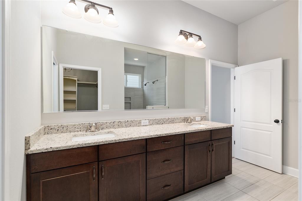 2556 Southwest 118th Terrace Gainesville, FL 32608 - Photo 34 of 72 a bathroom with a granite countertop sink and a mirror