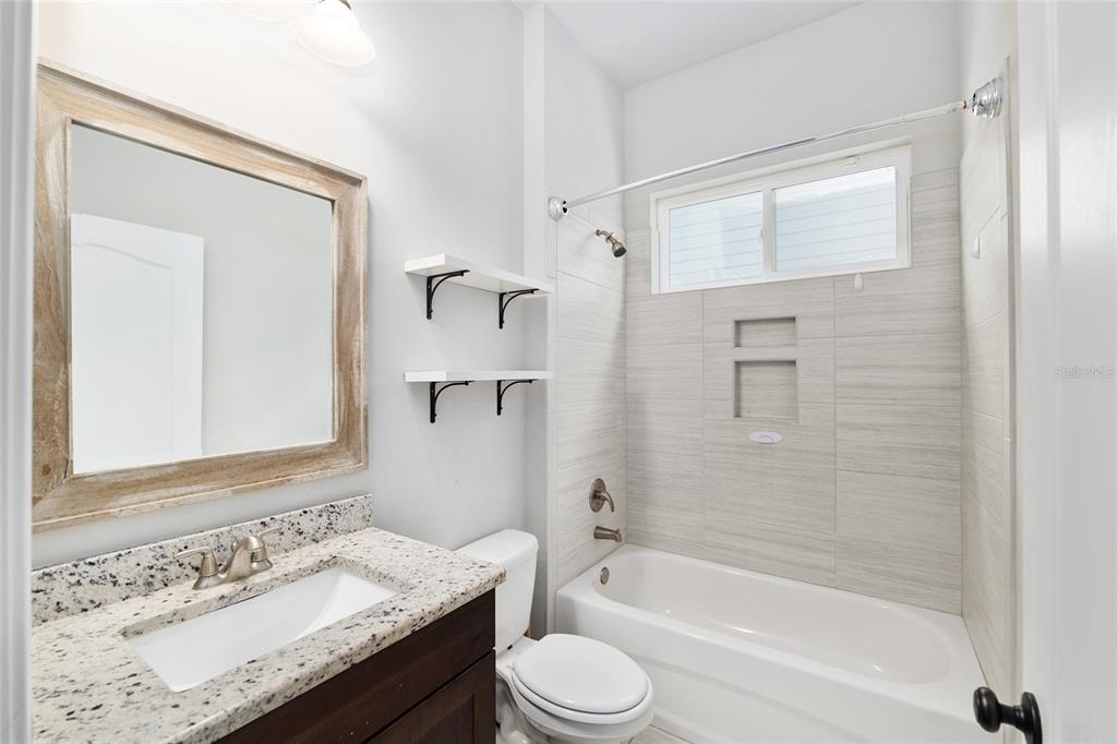 2556 Southwest 118th Terrace Gainesville, FL 32608 - Photo 42 of 72 a bathroom with a granite countertop sink toilet and shower