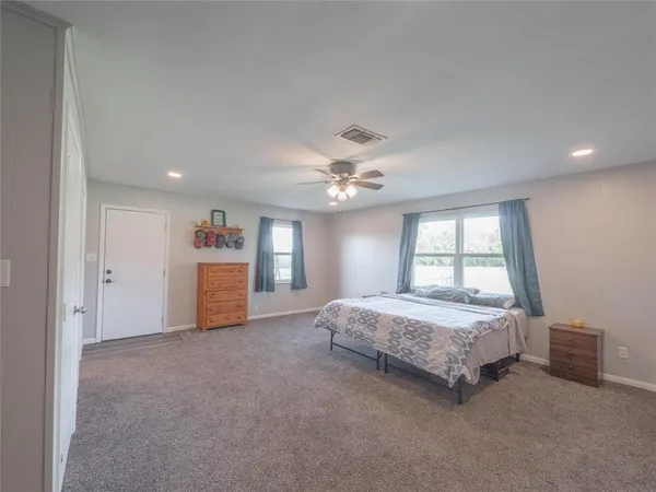 a spacious bedroom with a bed and a chandelier