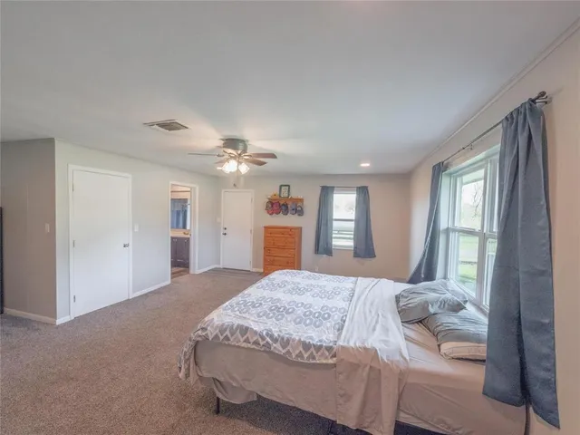 a bedroom with a large bed and a chandelier