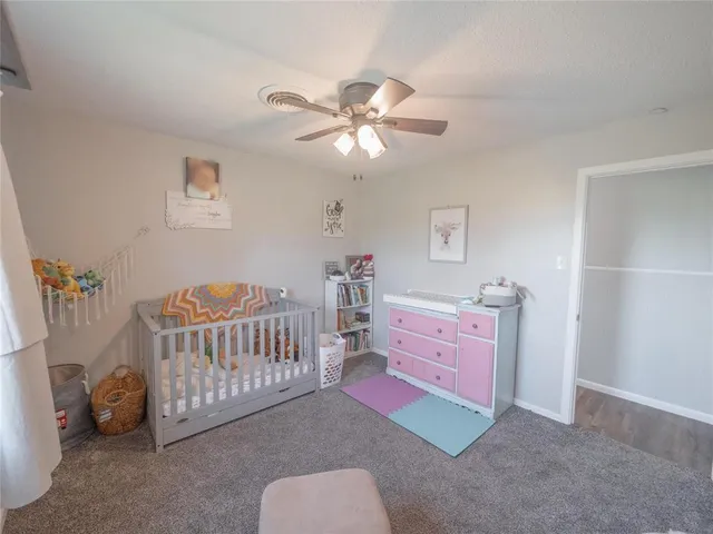 a bedroom with furniture and a chandelier fan