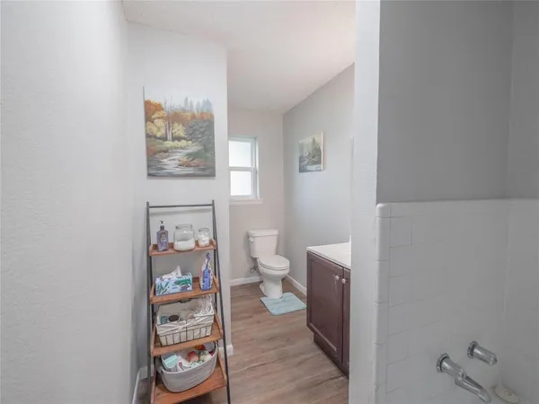 a bathroom with a toilet and a wooden floor