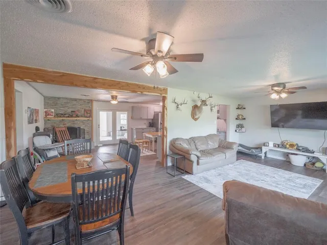 a living room with furniture a ceiling fan and a chandelier