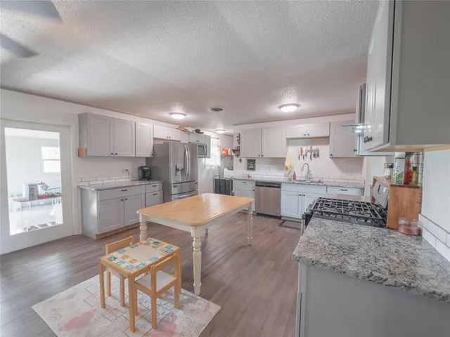 a kitchen with white cabinets and refrigerator