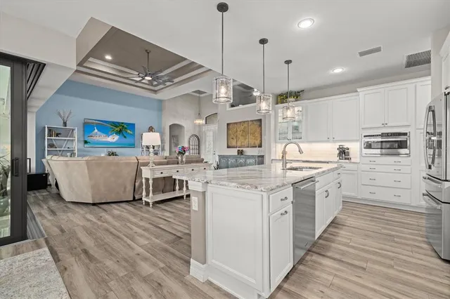 a kitchen with stainless steel appliances kitchen island granite countertop a stove a sink and a refrigerator