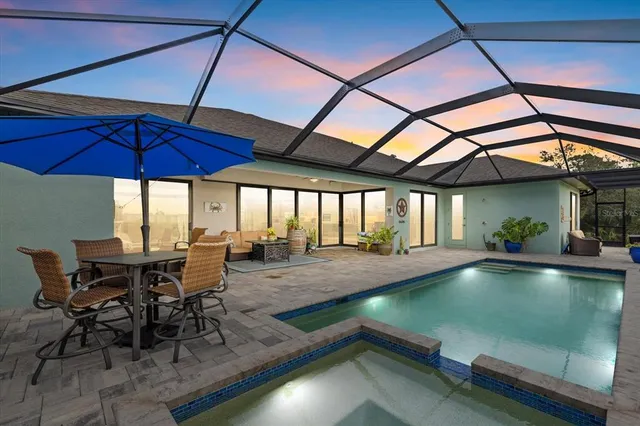 a view of a swimming pool with a table and chairs under an umbrella