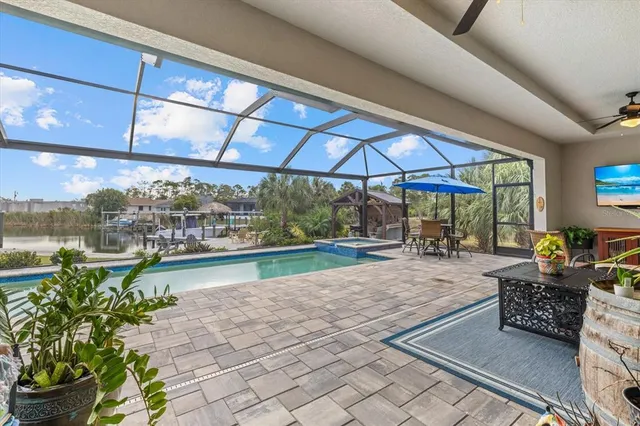 a view of a swimming pool with a table and chairs under an umbrella