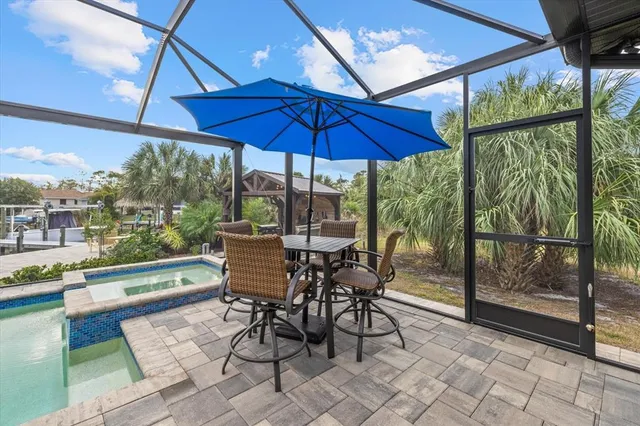 a view of a swimming pool with a lounge chair and couches in the patio