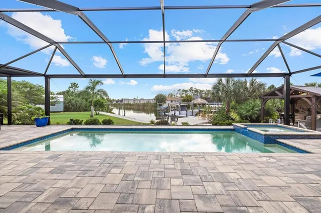 a view of a patio with table and chairs under an umbrella with a small yard