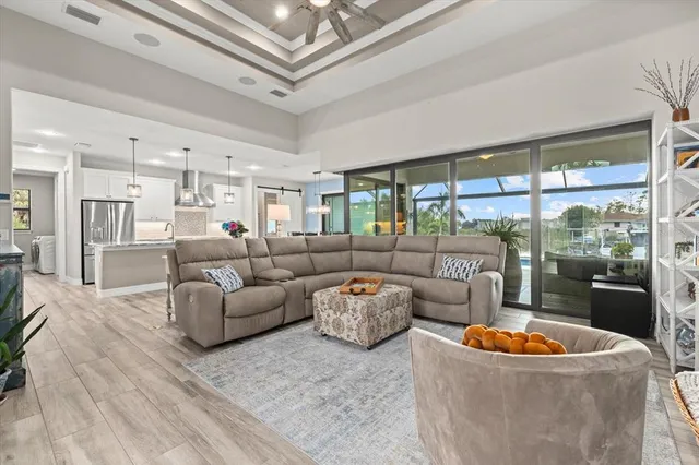 a living room with furniture a large window and a chandelier