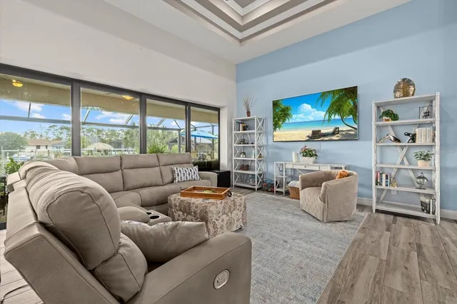 a living room with furniture a flat screen tv and a floor to ceiling window