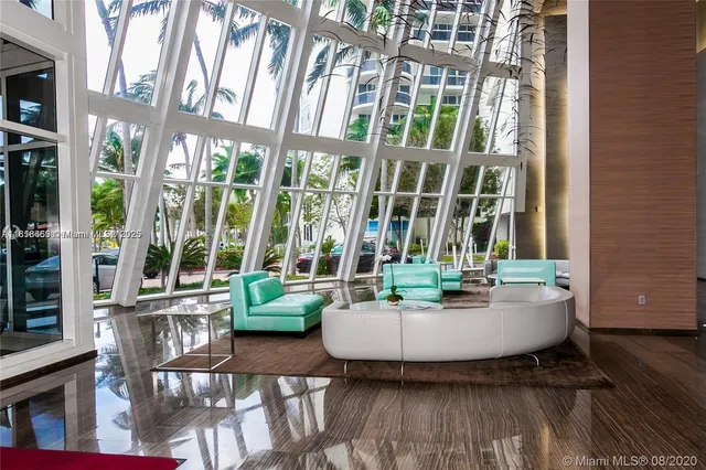 a view of a room with wooden floor and floor to ceiling windows