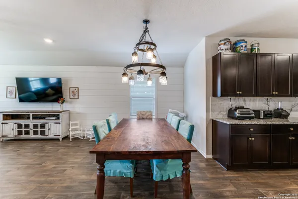 a large kitchen with stainless steel appliances and a view of living room