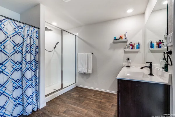 a bathroom with a double vanity sink mirror and shower