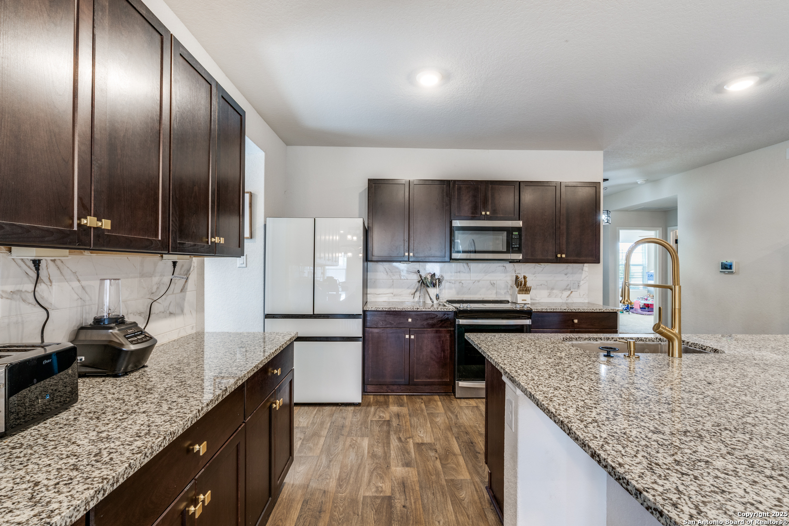 816 Indigo Way Seguin, TX 78155 - Photo 9 of 25 a kitchen with granite countertop stainless steel appliances and sink