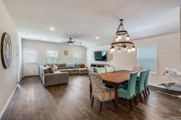 a kitchen with stainless steel appliances wooden floor dining table and chairs