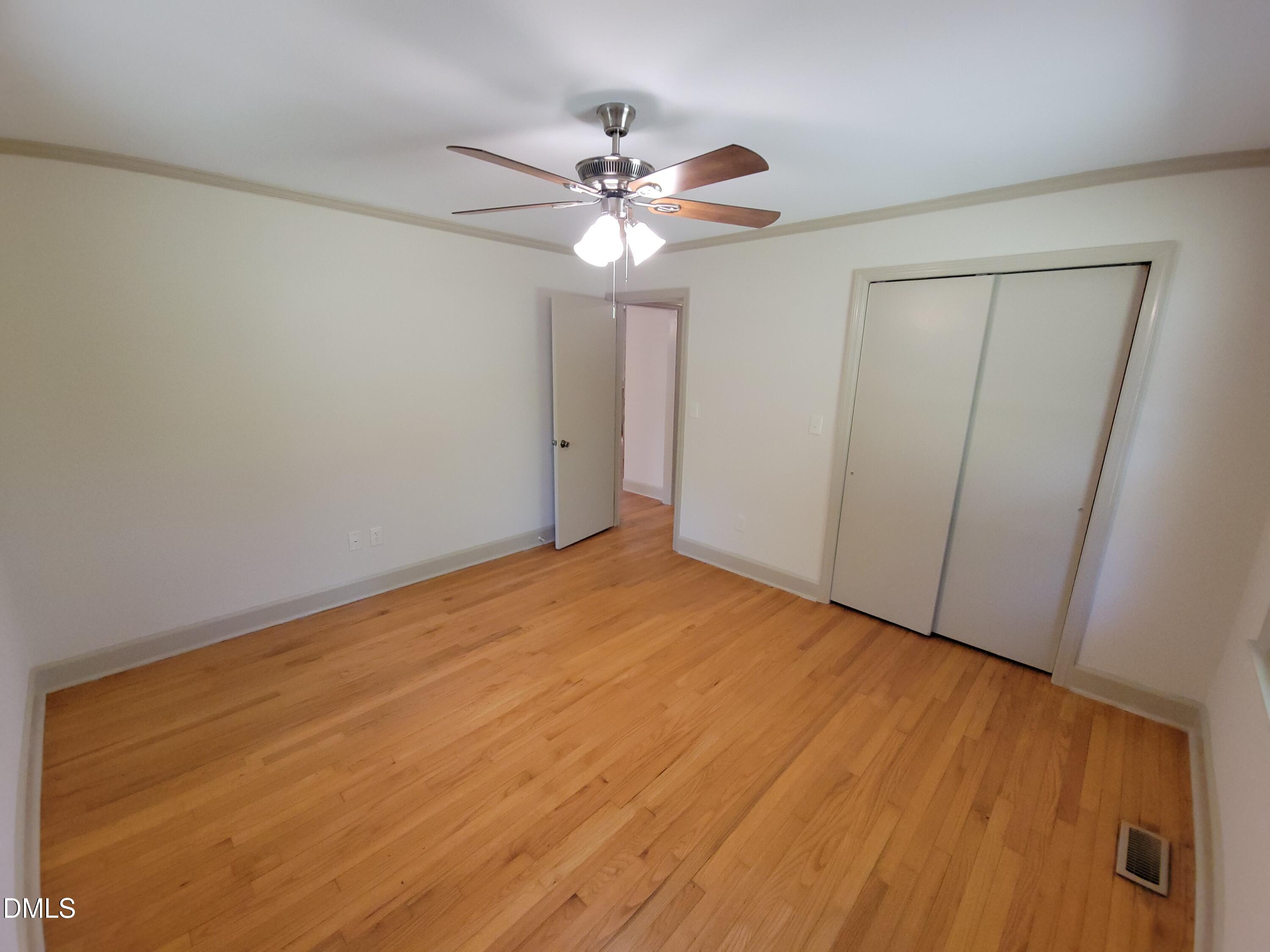 7000 Holly Springs Road Raleigh, NC 27606 - Photo 18 of 24 a view of an empty room with wooden floor