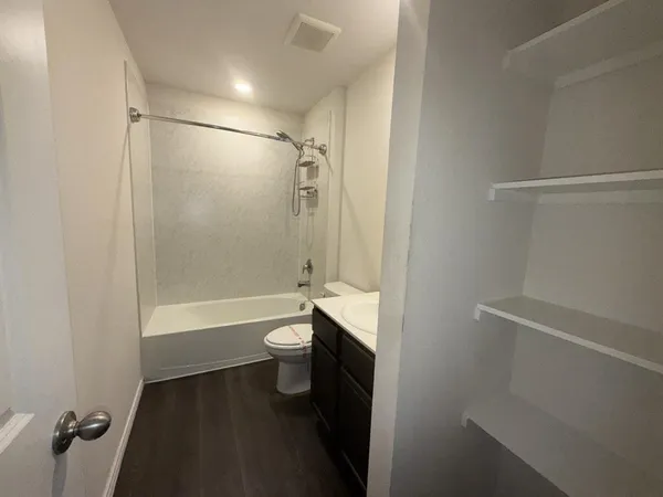 a view of kitchen with kitchen island a sink wooden floor and a stove top oven
