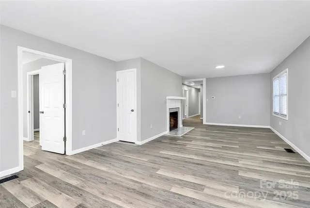 a view of empty room with wooden floor and window