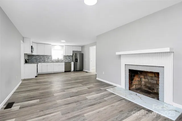 a view of a livingroom with a fireplace a ceiling fan and window
