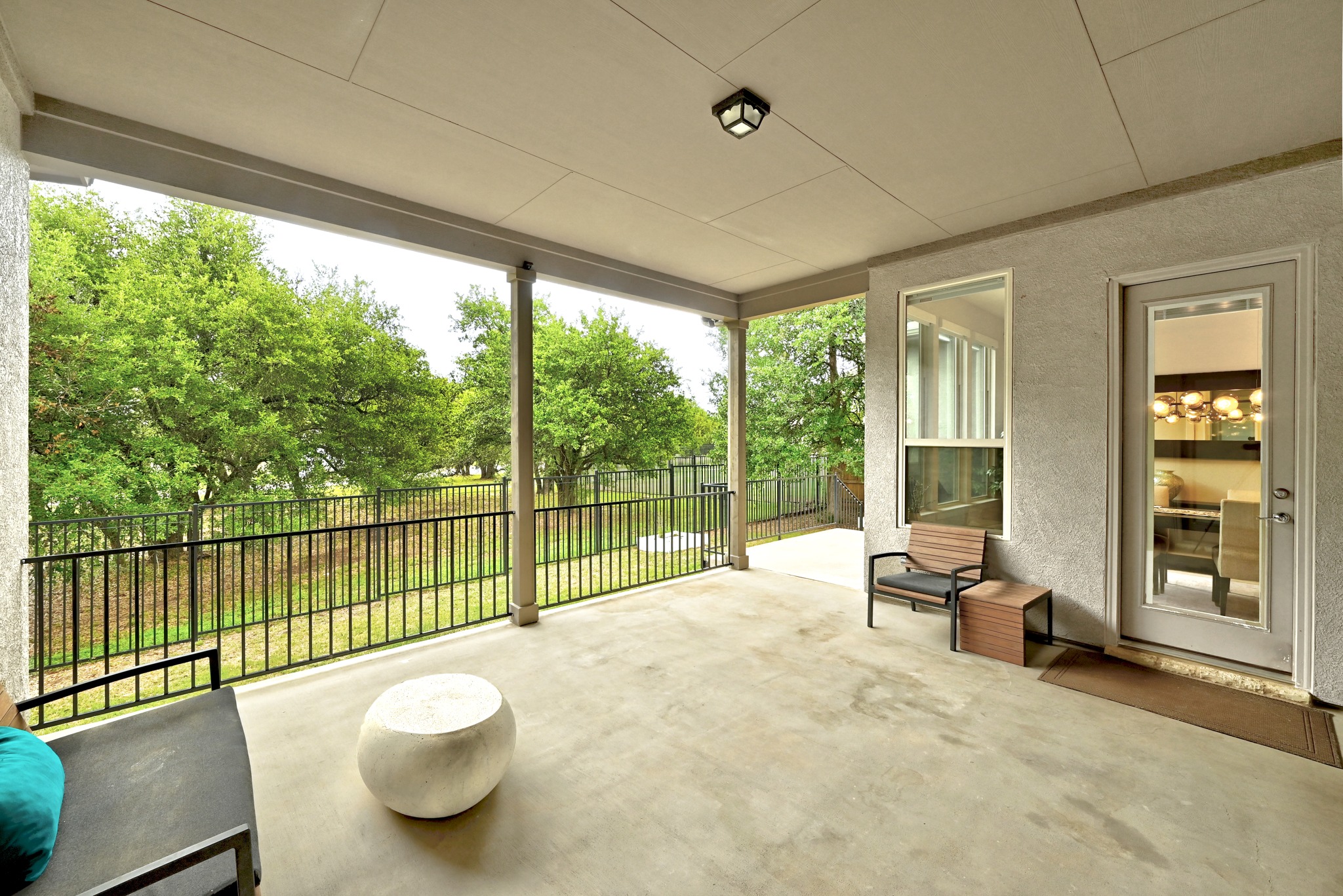 9008 Harper Rae Drive Austin, TX 78717 - Photo 37 of 39 Covered patio featuring a concrete floor, stucco exterior, and black metal railing