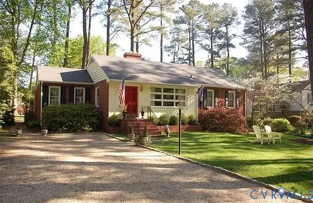 a front view of a house with a garden and trees