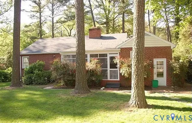 a view of a house with backyard and a tree