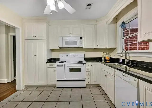 a kitchen with a stove sink and cabinets