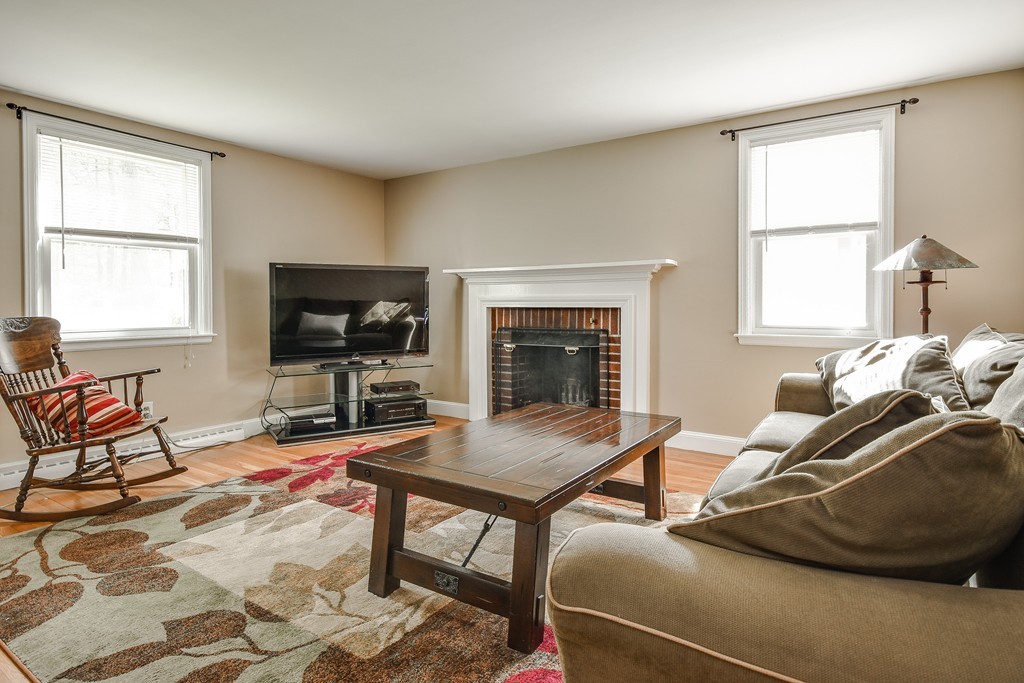 27 Stonebridge Road Wayland, MA 01778 - Photo 8 of 19 a living room with furniture a flat screen tv and a fireplace