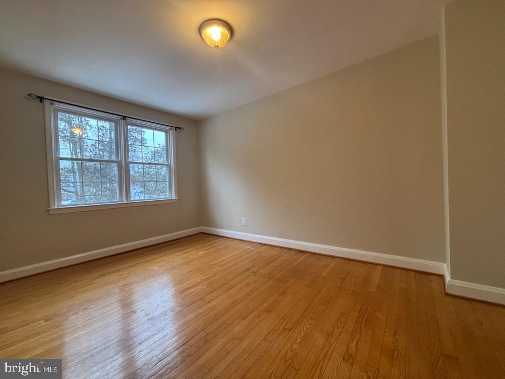 7028 Heathfield Road Baltimore, MD 21212 - Photo 17 of 23 an empty room with wooden floor and windows