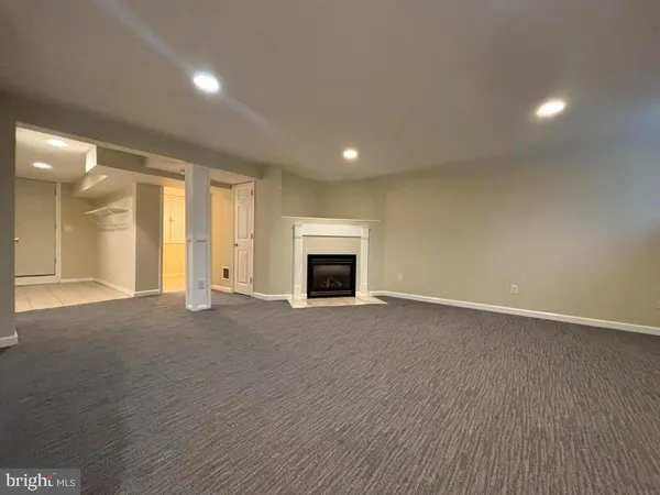an empty room with fireplace and wooden floor