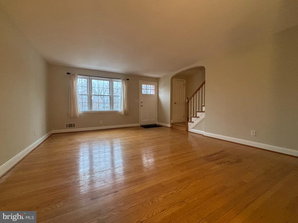 7028 Heathfield Road Baltimore, MD 21212 - Photo 4 of 23 an empty room with wooden floor and windows