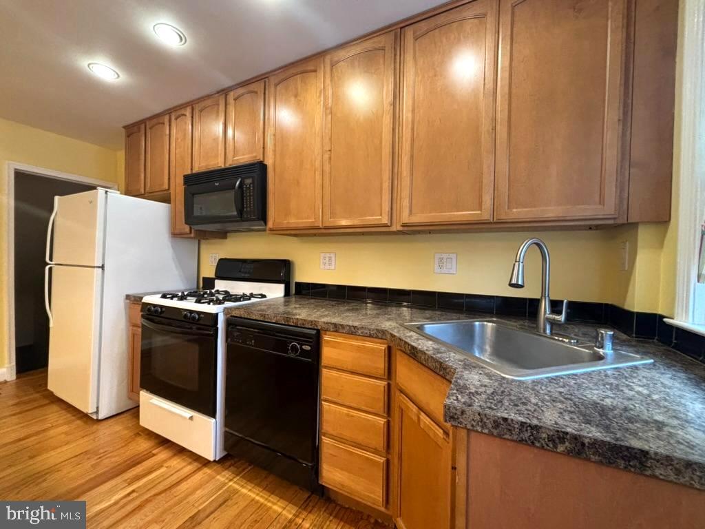 7028 Heathfield Road Baltimore, MD 21212 - Photo 9 of 23 a kitchen with stainless steel appliances granite countertop a sink a stove a refrigerator a washer dryer and cabinets