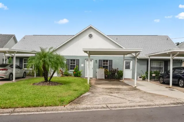 a front view of a house with a yard and potted plants