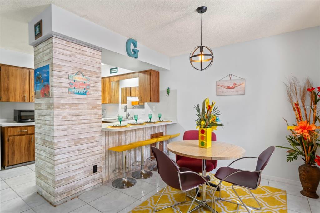 6101 Elmhurst Drive, Unit 5B New Port Richey, FL 34653 - Photo 14 of 45 a dining room filled chandelier and wooden floor