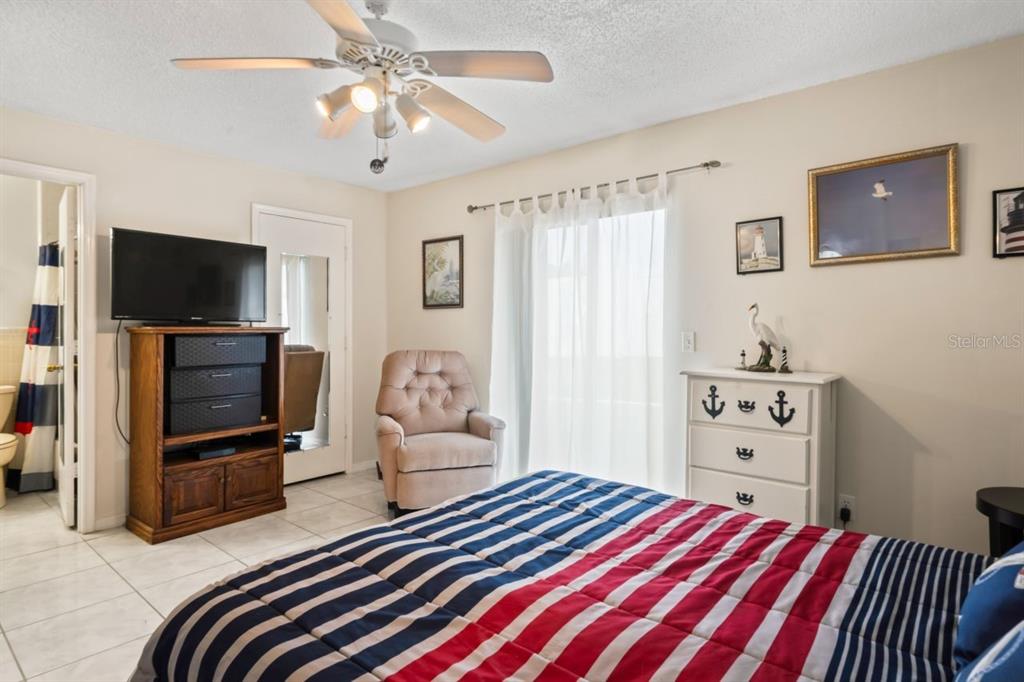 6101 Elmhurst Drive, Unit 5B New Port Richey, FL 34653 - Photo 17 of 45 a bedroom with a bed and a flat screen tv